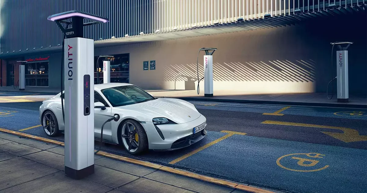 Carro elétrico Porsche Taycan estacionado em uma estação de carregamento.