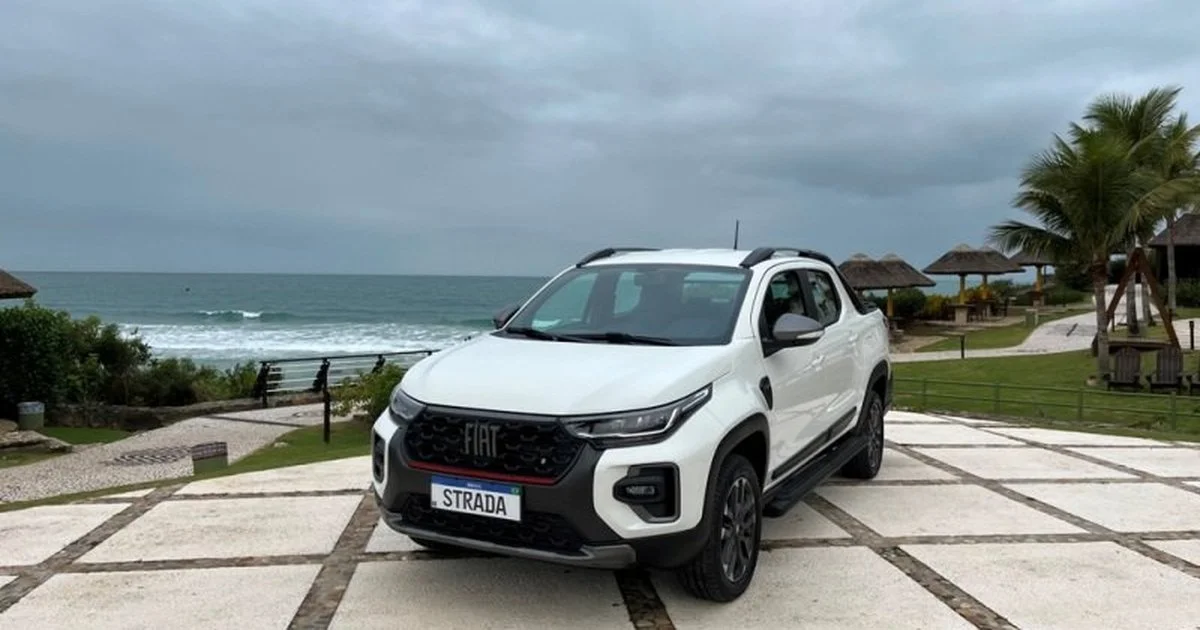 Vista frontal de uma Fiat Strada próximo à praia.