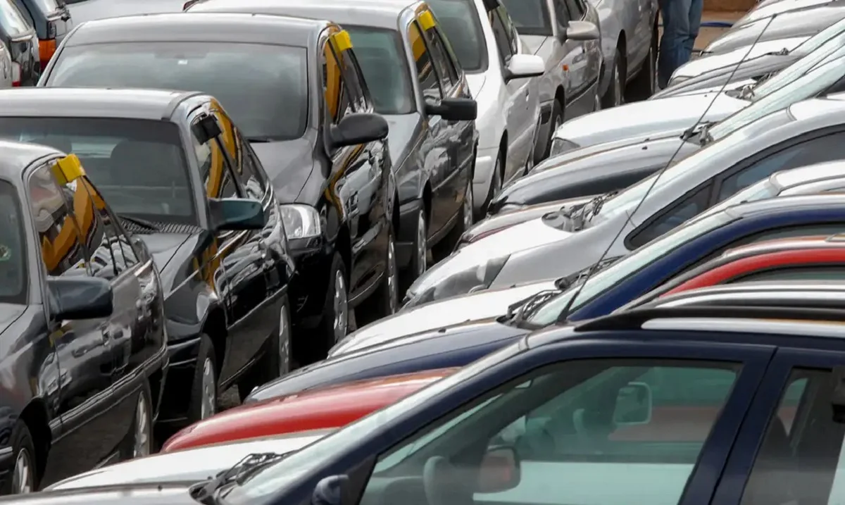 V&aacute;rios carros estacionados em linha.