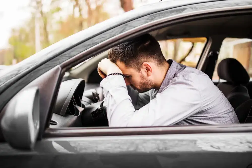 Homem preocupado com carro com capô aberto.