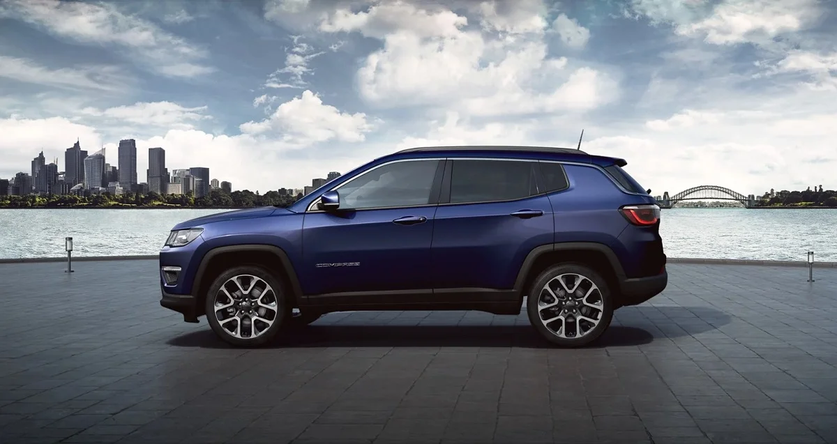 Jeep Compass azul estacionado com vista para uma cidade