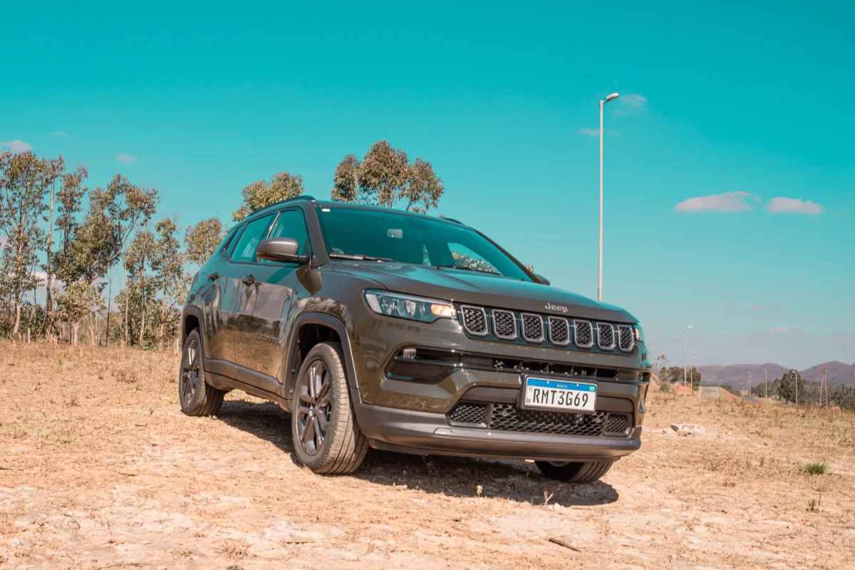 Jeep Compass 1.3 turbo modelo 2012 cinza escuro est&aacute;tico de frente na terra