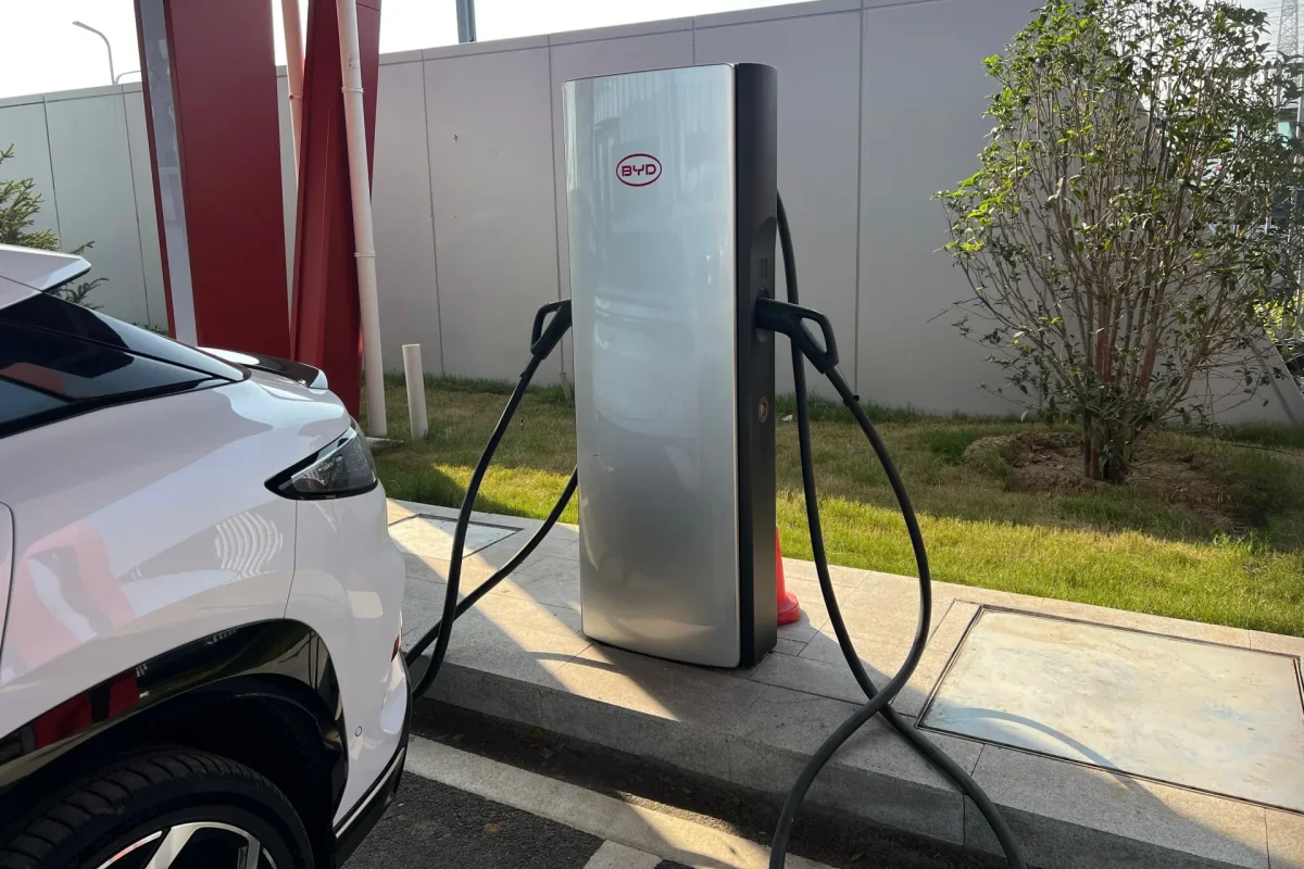 Carregador BYD para ve&iacute;culos el&eacute;tricos ao lado de um carro.