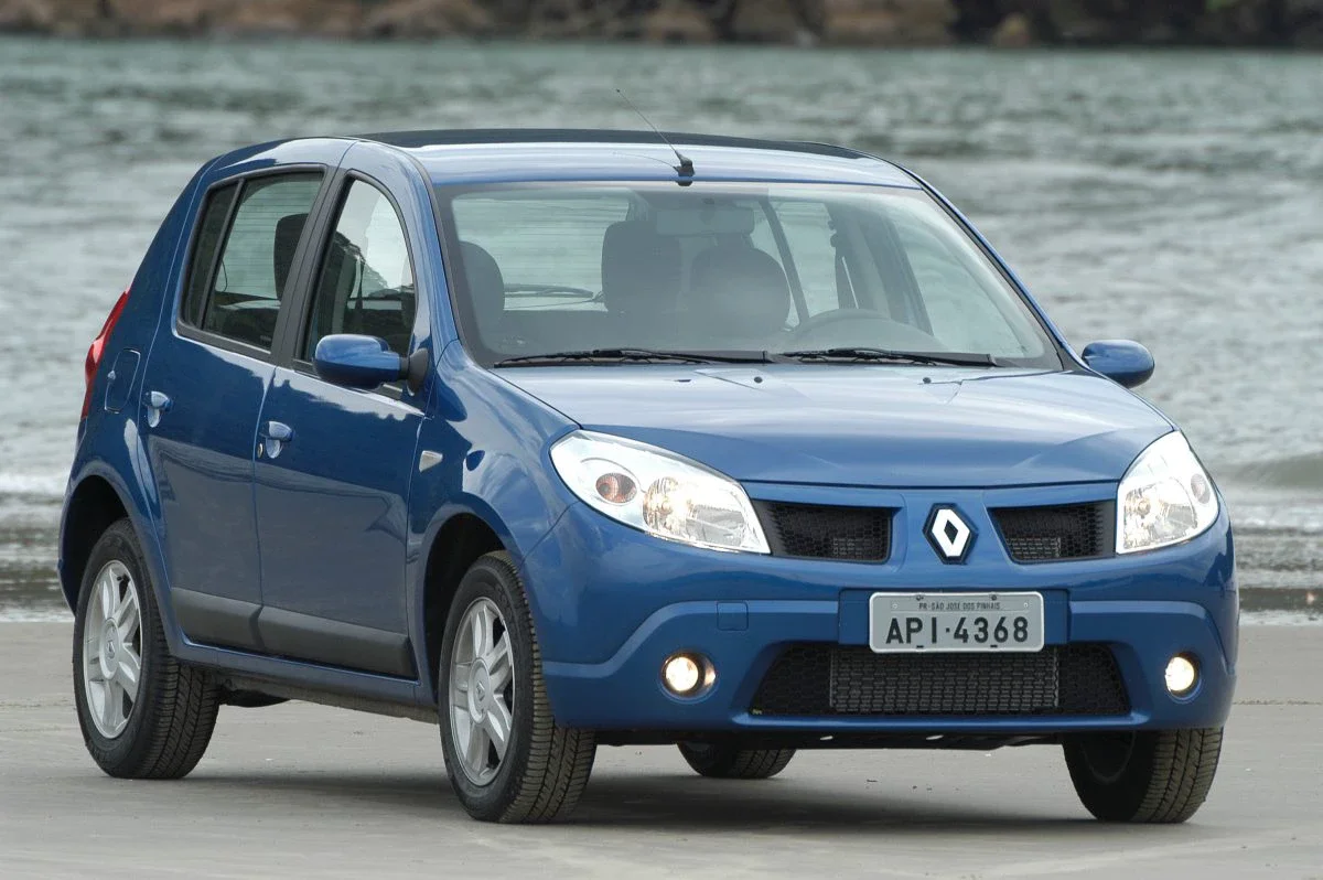 Renault Sandero azul estacionado na praia.