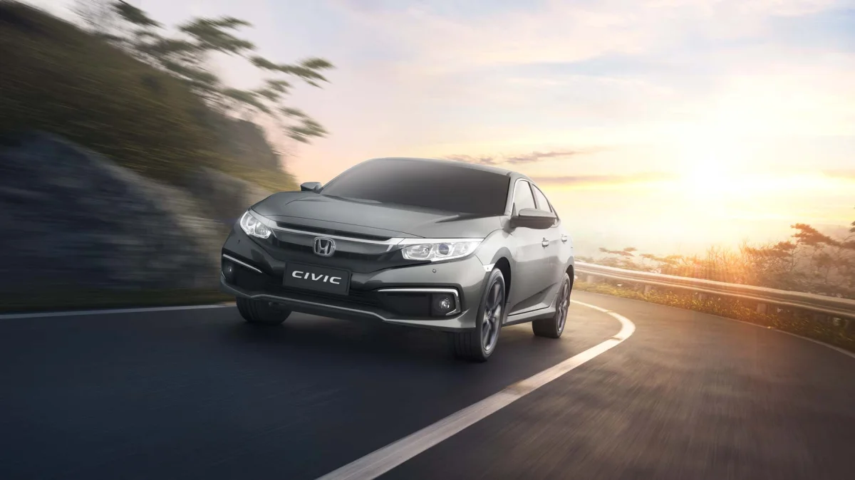 Carro Honda Civic em uma estrada ao pôr do sol.