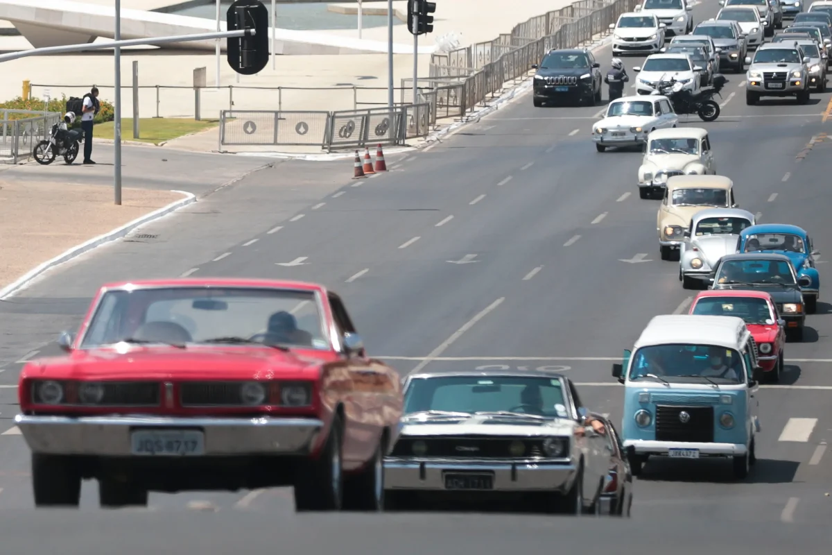 Carros antigos em uma avenida movimentada, simbolizando a isenção do IPVA.