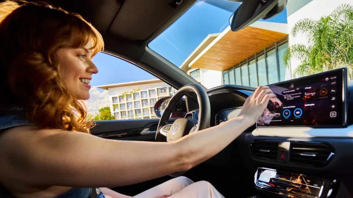 Mulher interagindo com a tela de um carro moderno
