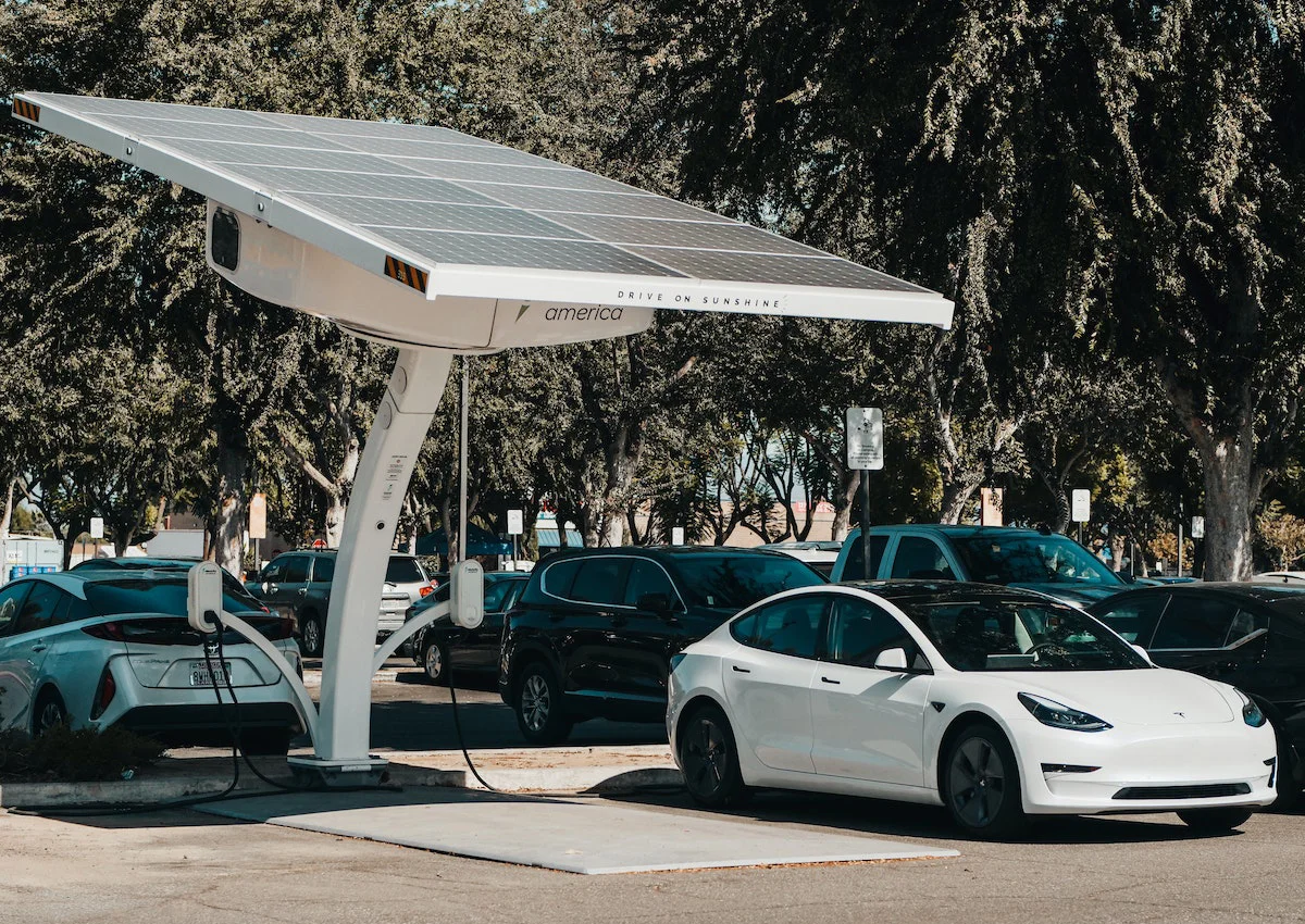 Carro elétrico em estação de carregamento ao ar livre.
