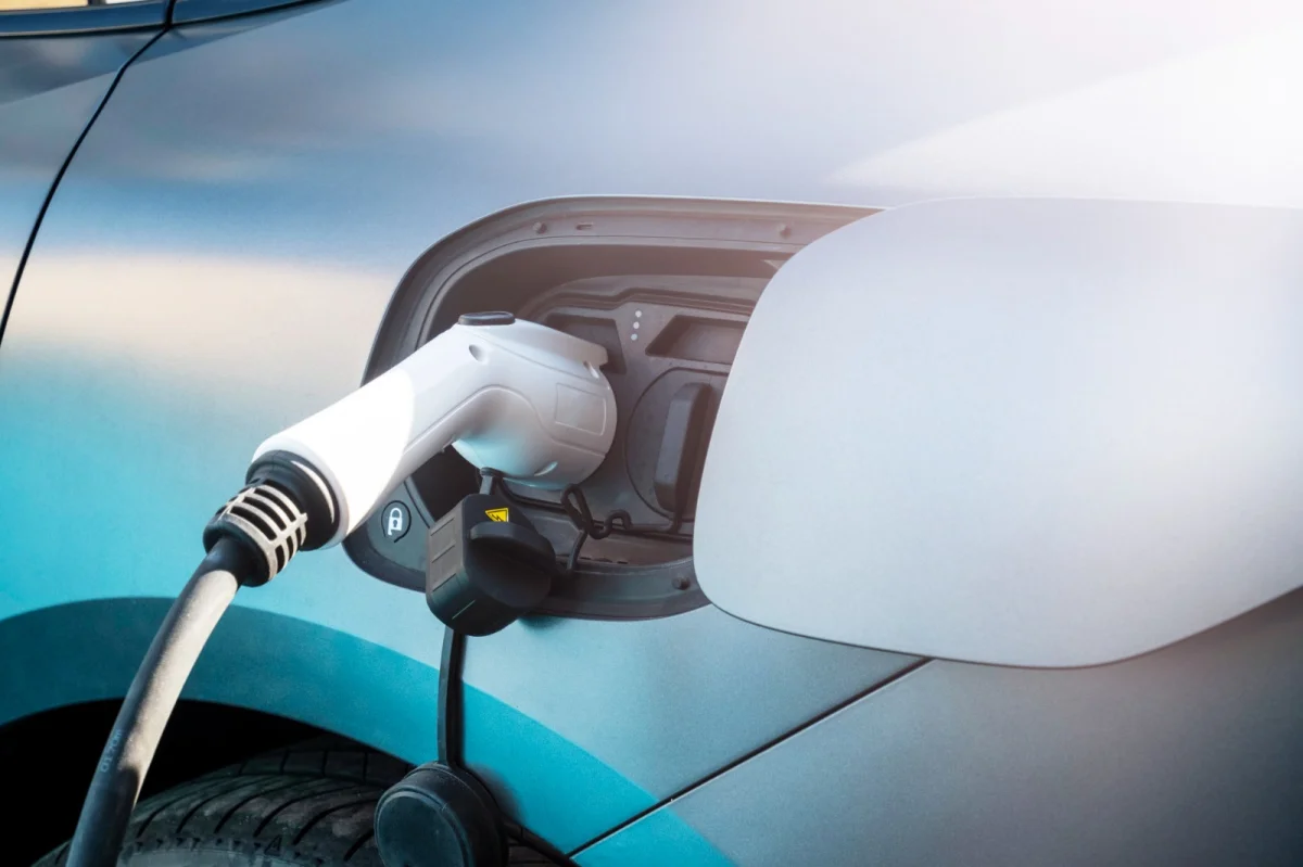 Detalhe de um carro el&eacute;trico sendo carregado.
