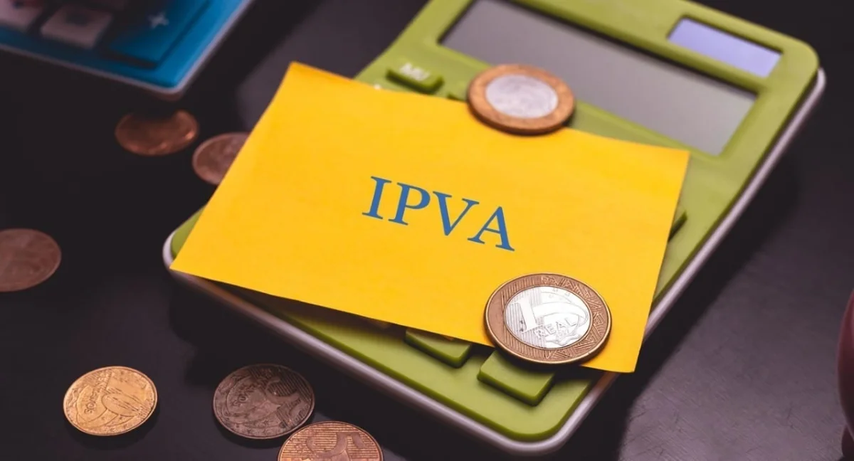 Calculadora com moedas e um papel amarelo escrito IPVA.