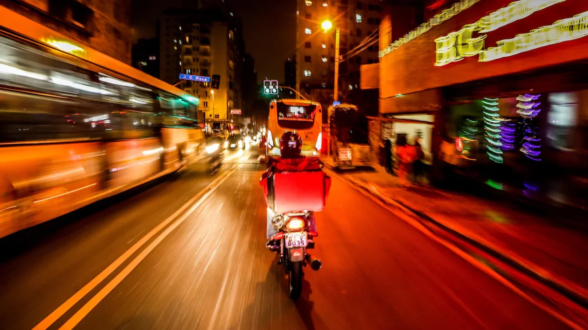 Motociclista em uma avenida movimentada &agrave; noite.
