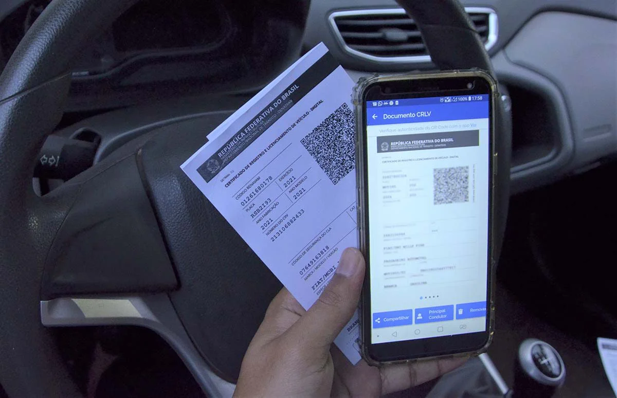 Documento de carro e aplicativo no celular.