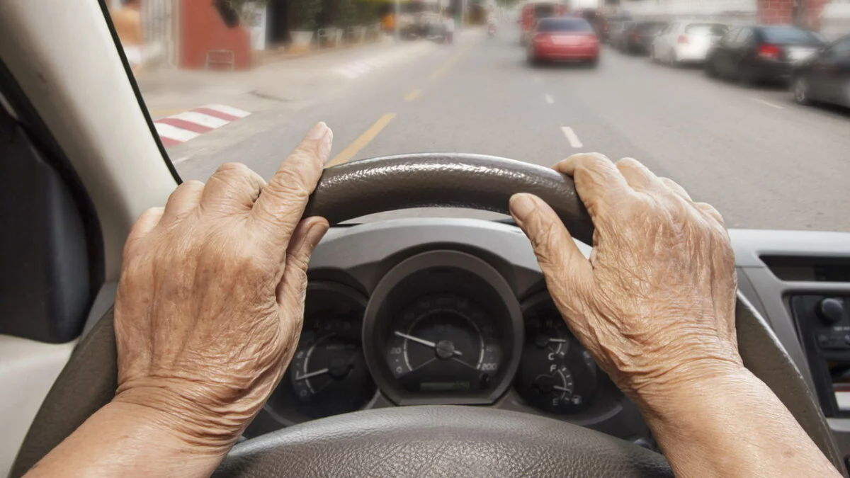 Condutor idoso ao volante.