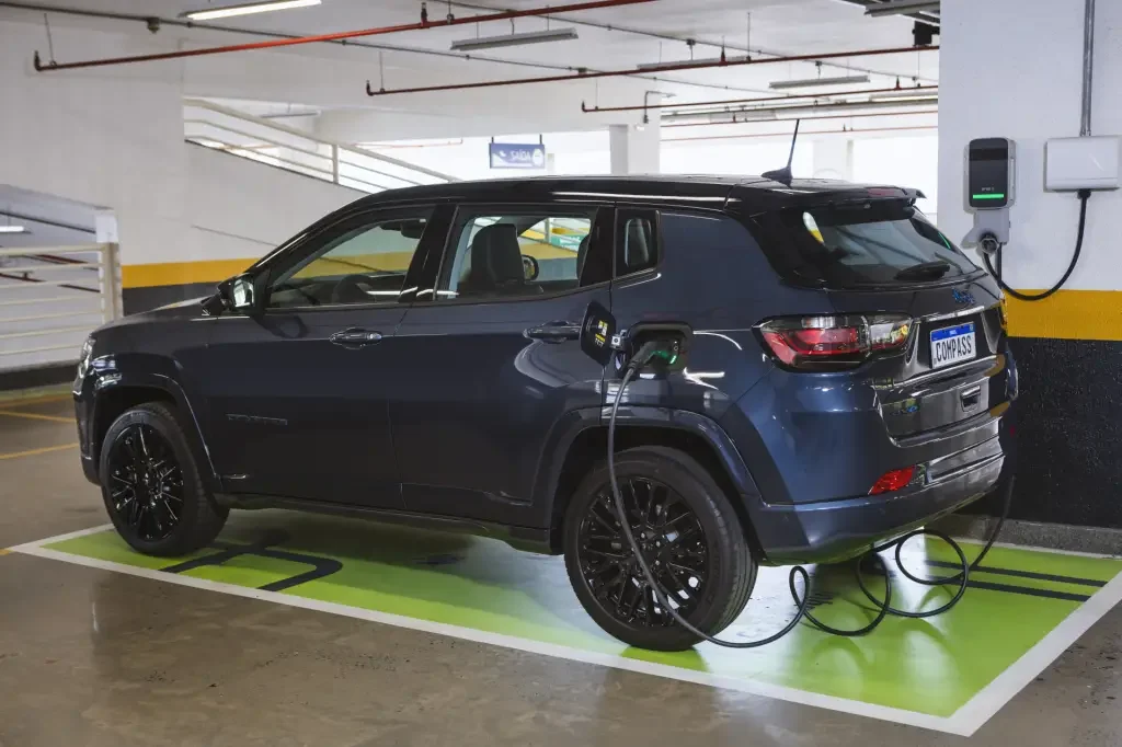 Jeep Compass 4xe carregando em estacionamento.
