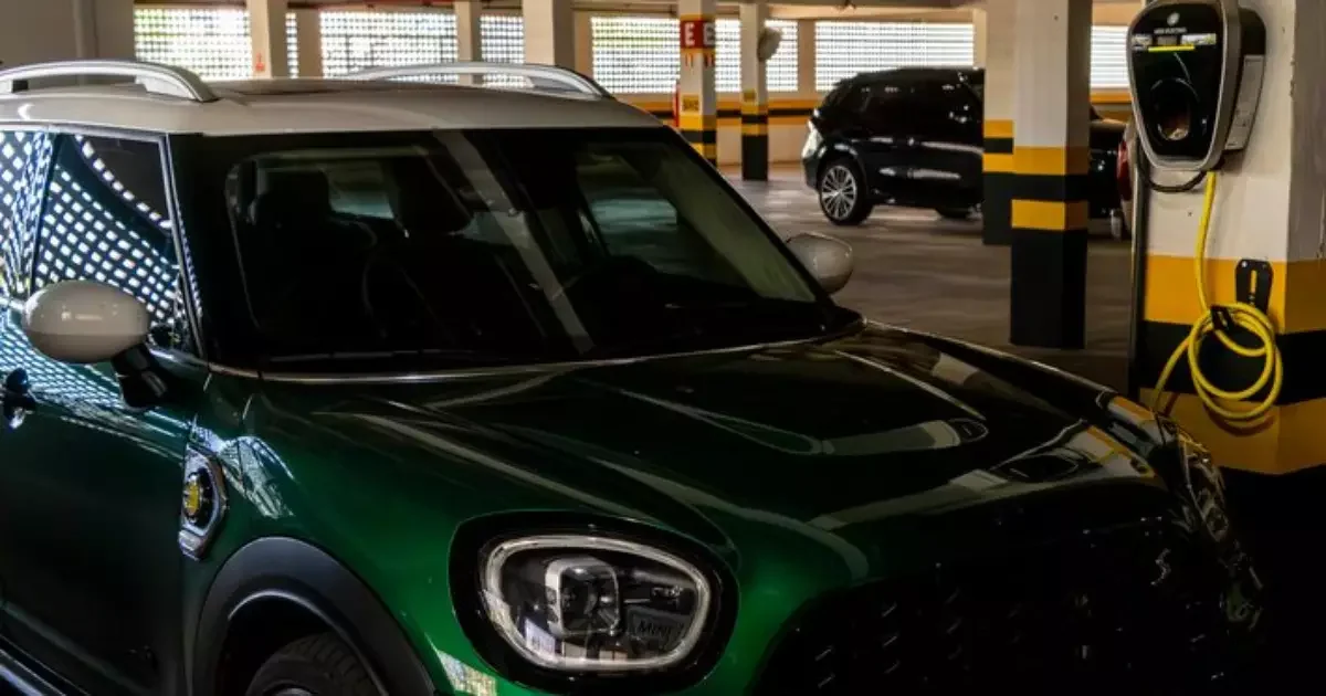 Carro em processo de carregamento em estação pública.