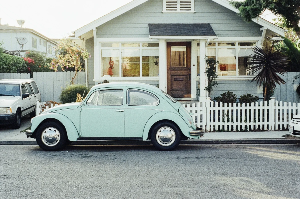 Fusca estacionado em frente a uma casa.