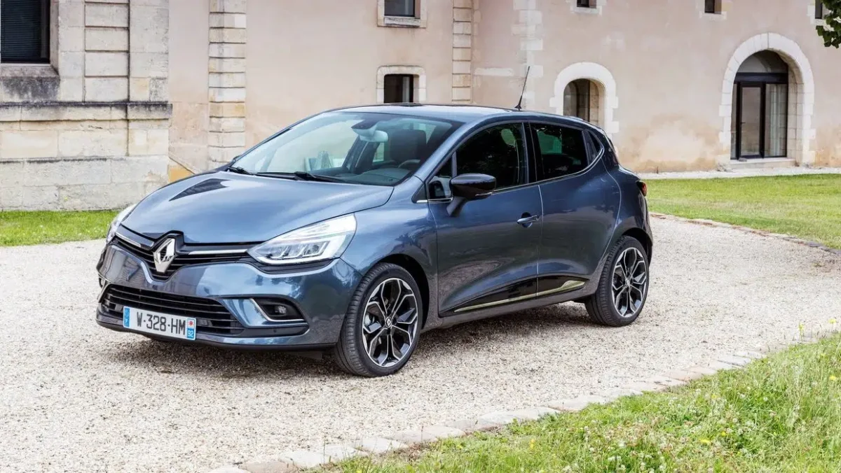Renault Clio 2017 estacionado perto de uma construção antiga.