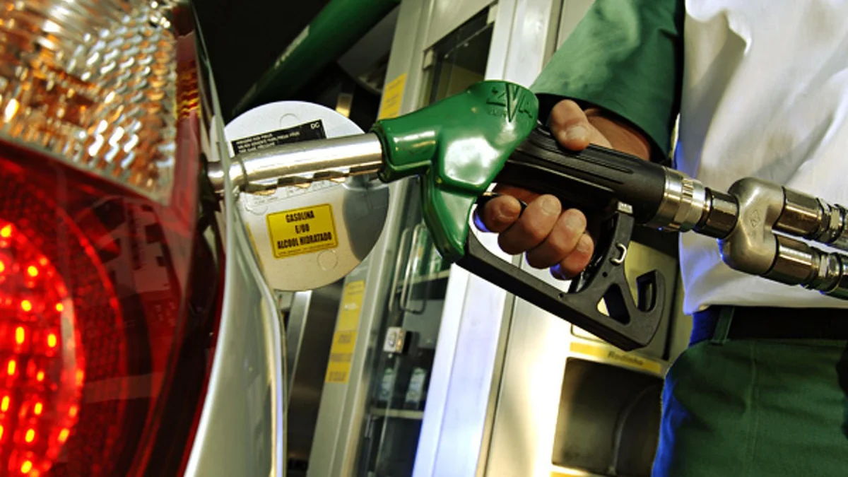 Homem abastecendo carro em posto de combust&iacute;vel