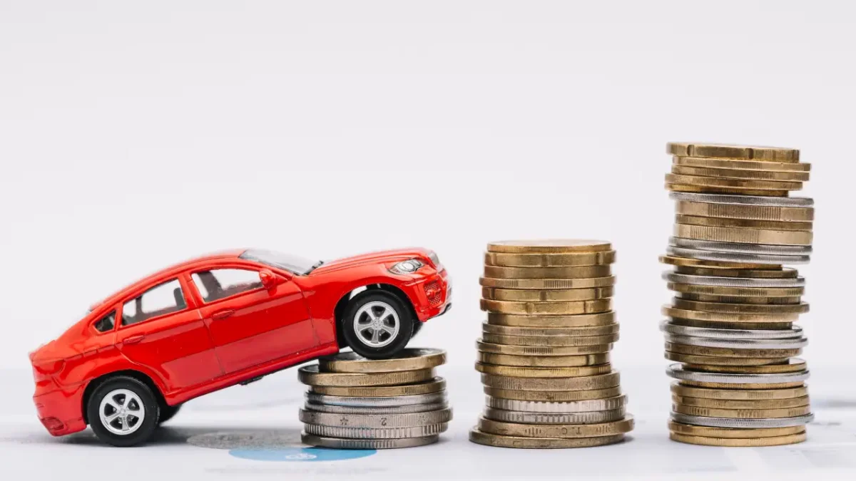Carro subindo em pilhas de moedas.