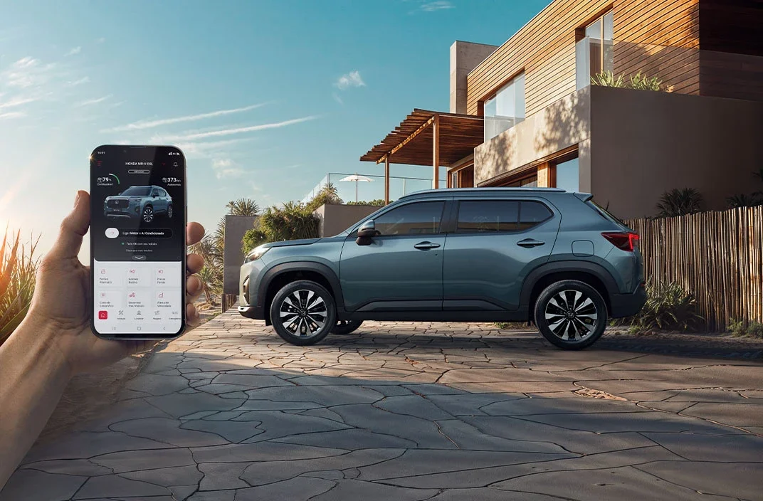 Aplicativo myHonda Connect mostrado em smartphone em frente ao WR-V.