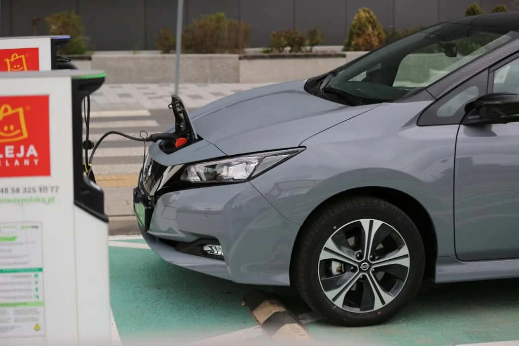 Carro elétrico sendo recarregado em uma estação.