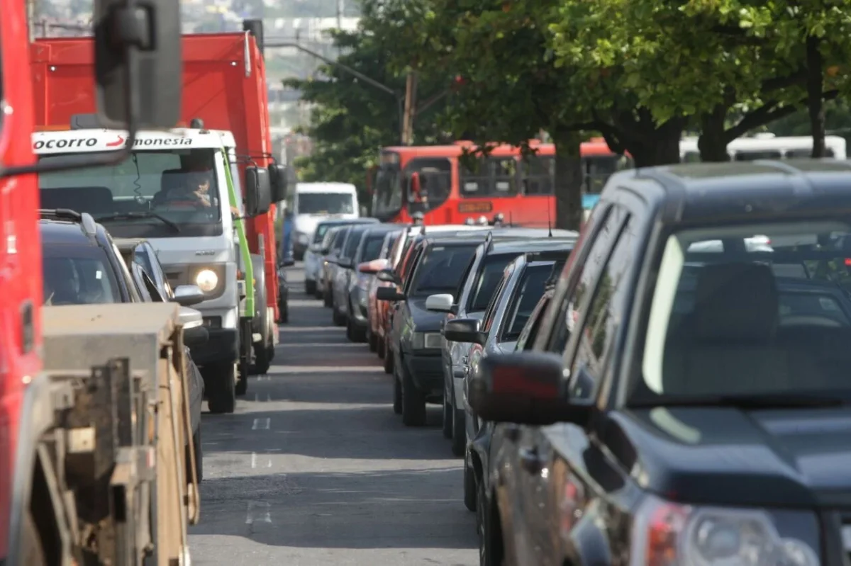 Trânsito pesado na cidade, carros alinhados.