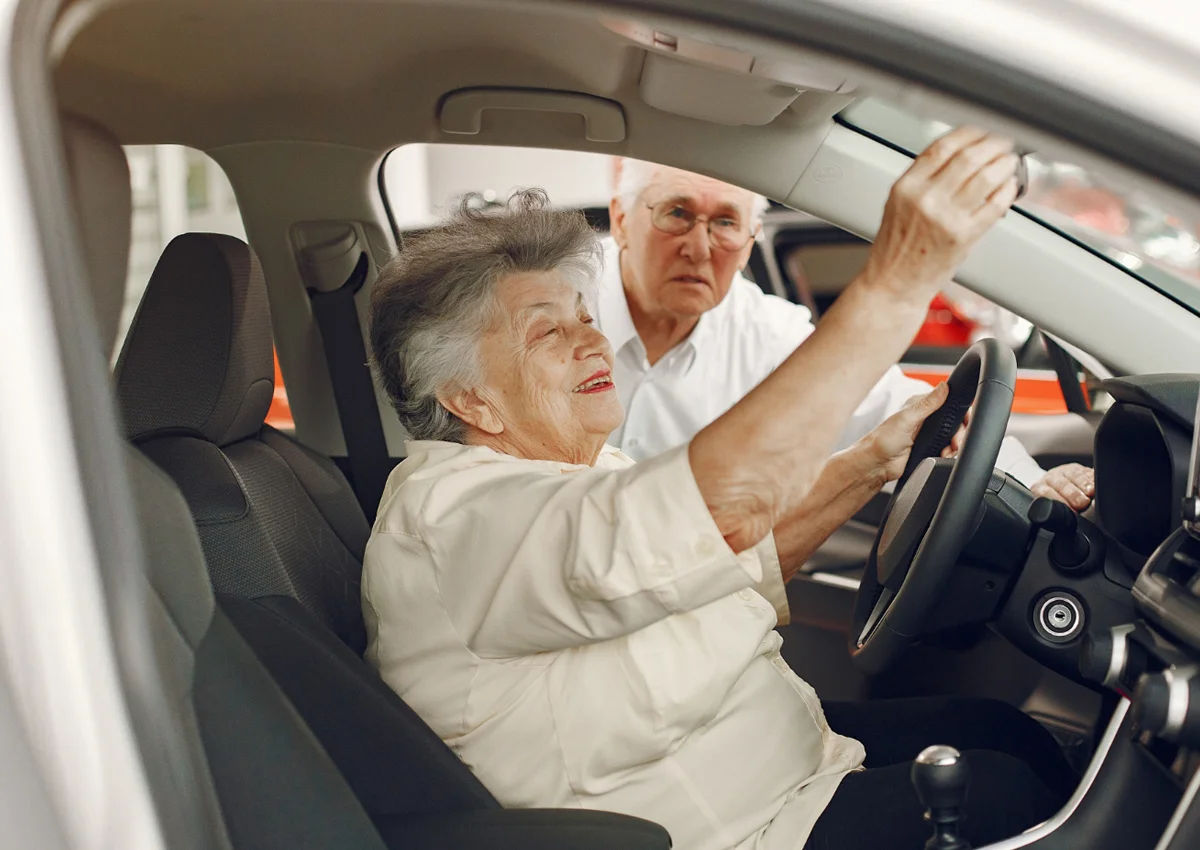 Pessoas idosas dentro de um carro.