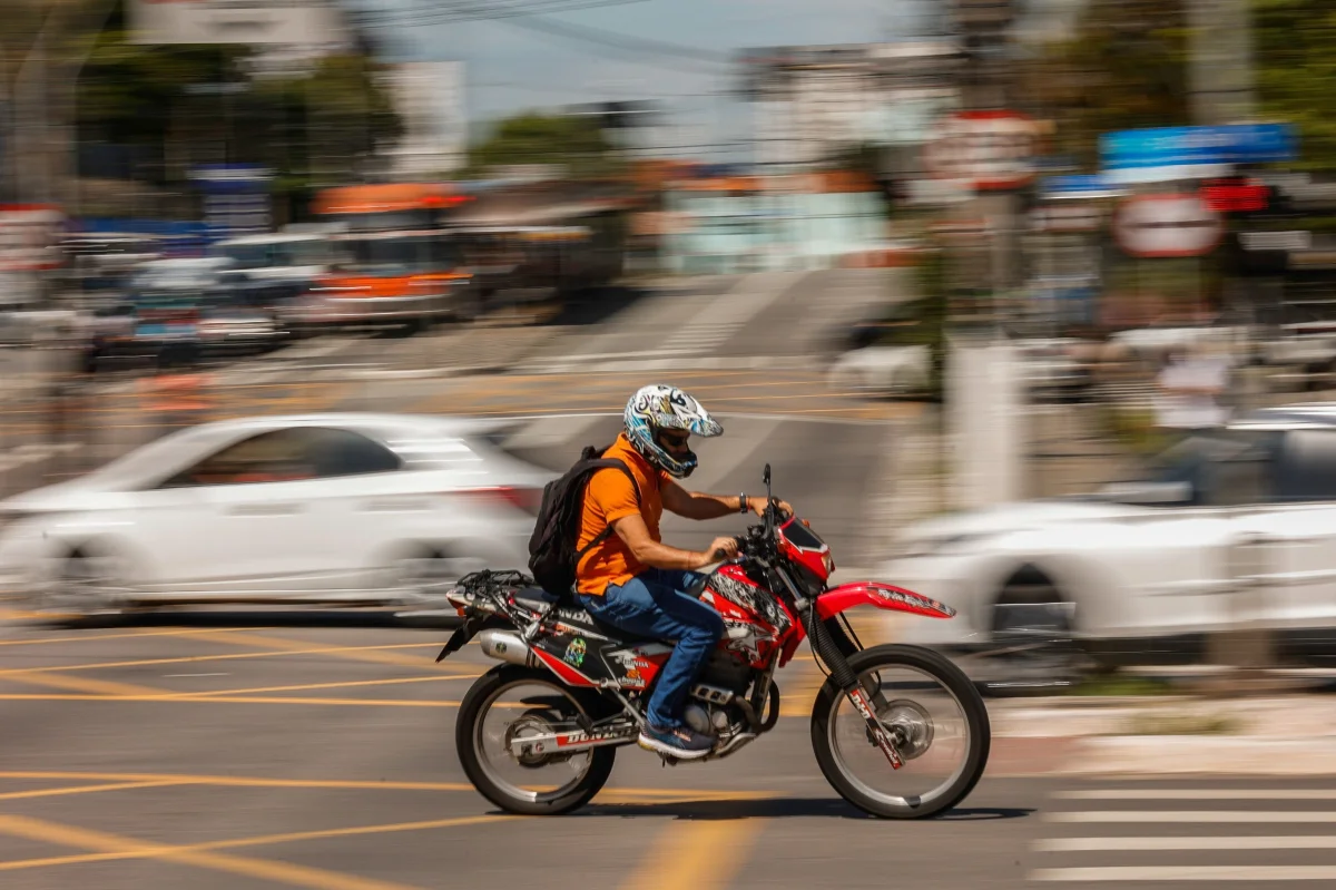 Motociclista em movimento em área urbana.