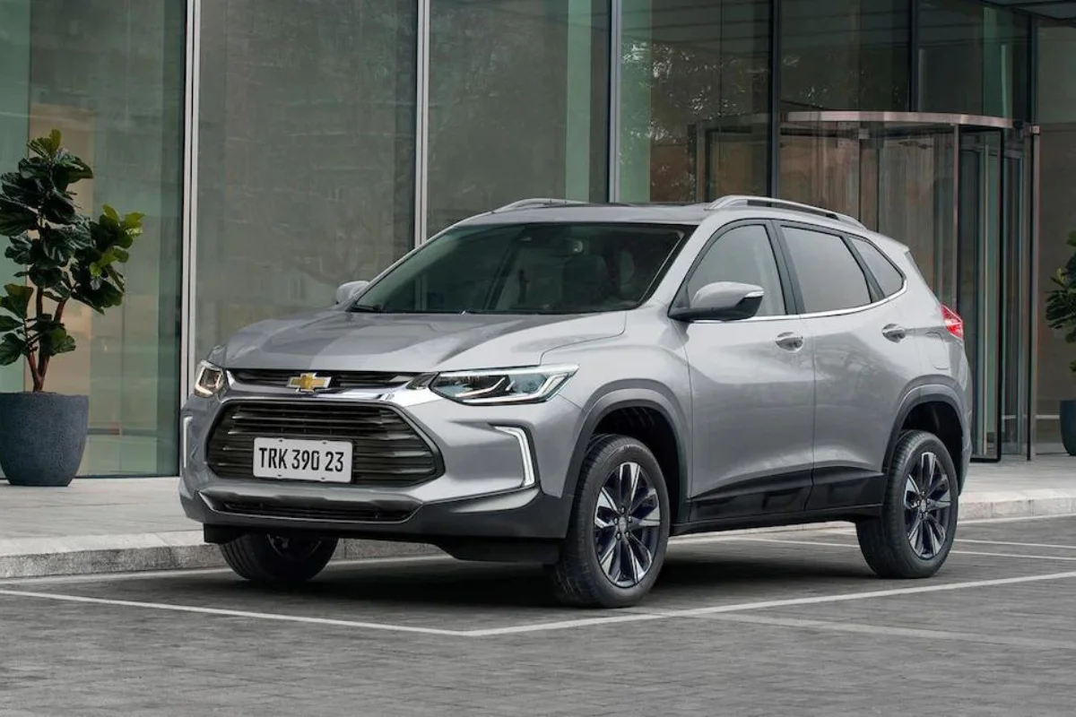 Chevrolet SUV prateado estacionado em frente a um prédio comercial.