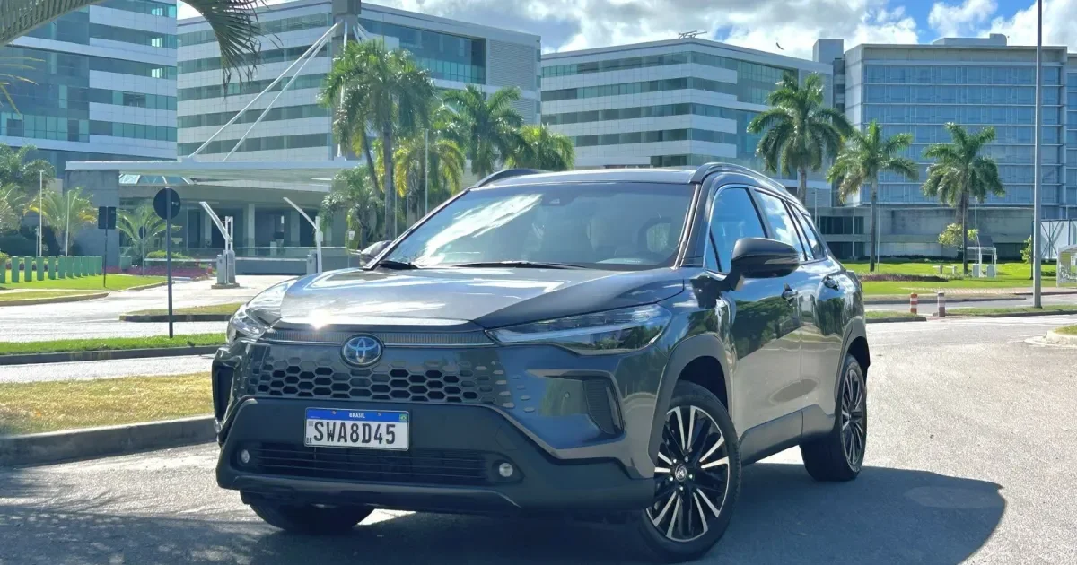 Toyota Corolla Cross Hybrid azul estacionado em frente a um edifício.