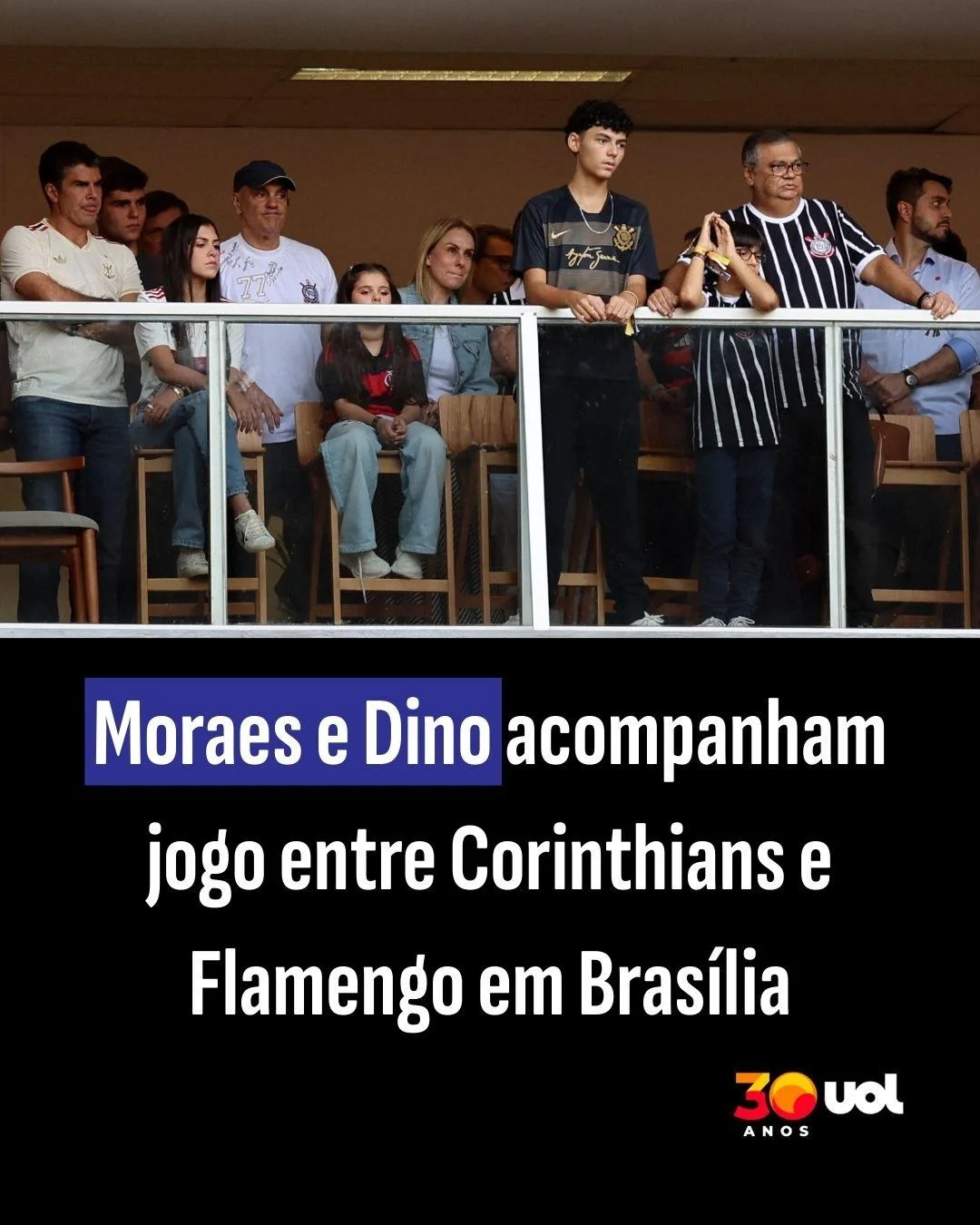 Grupo de pessoas assistindo a um jogo de futebol.
