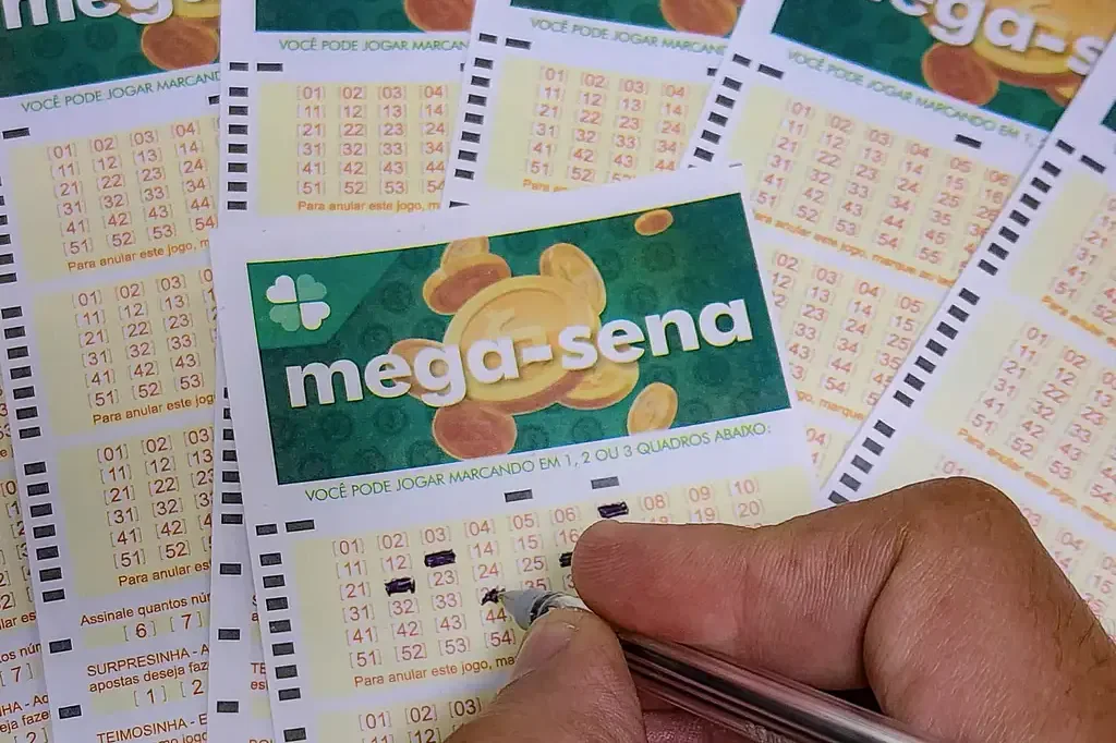 Imagem de uma m&atilde;o preenchendo um bilhete de loteria da Mega-Sena.