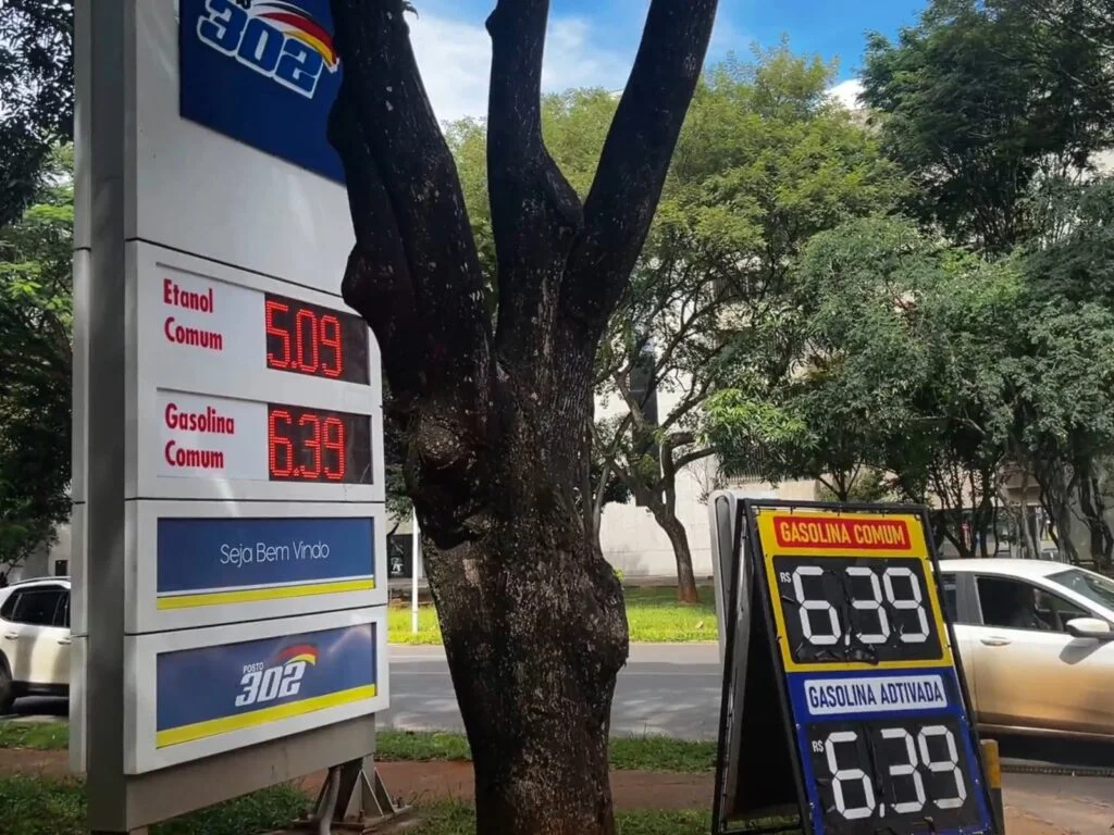 &Aacute;rvores em torno de um posto de gasolina com pre&ccedil;os em exibi&ccedil;&atilde;o.