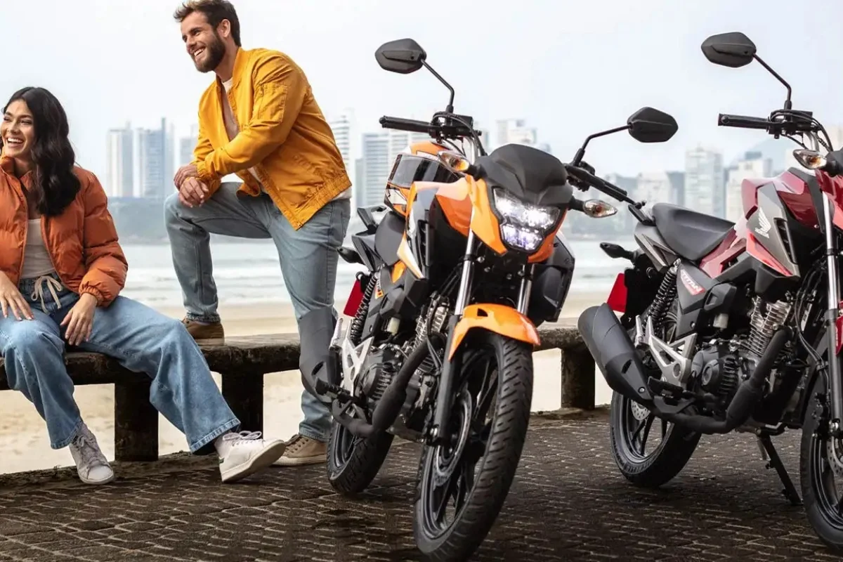 Duas motocicletas CG 160 Titan em frente a uma paisagem urbana.