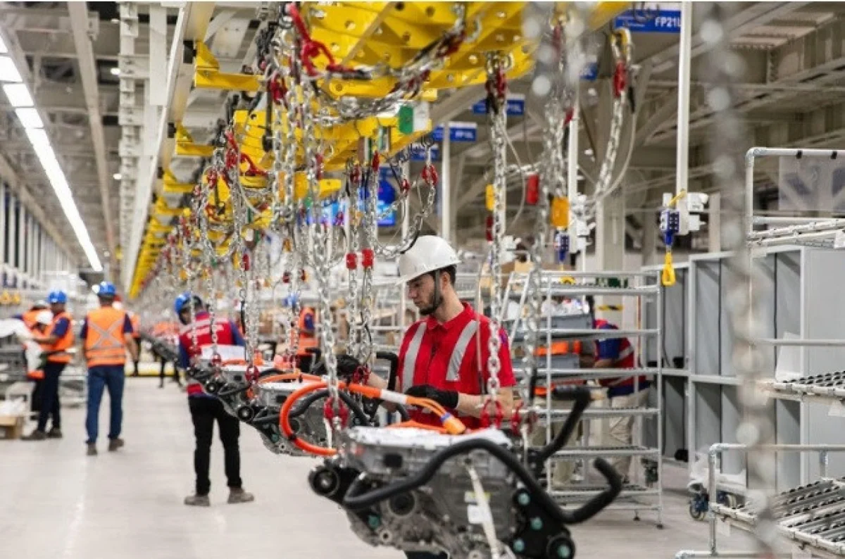 Funcionários em linha de produção automotiva.