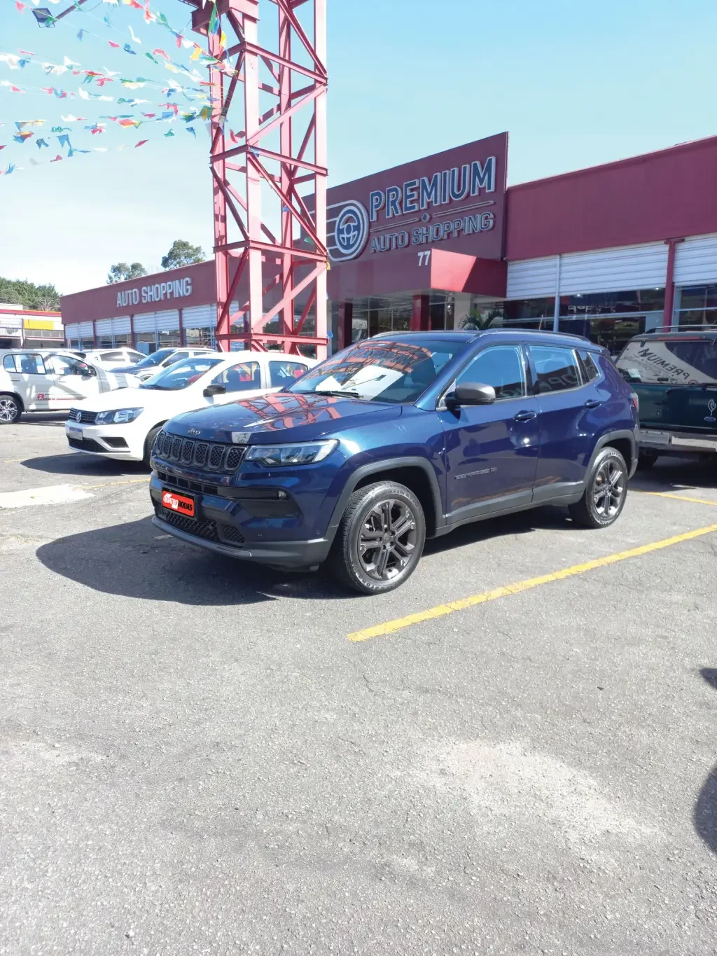 Jeep Compass azul em um estacionamento de concession&aacute;ria