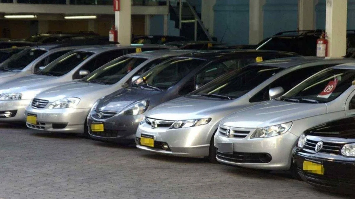 Vários carros estacionados em um pátio coberto.