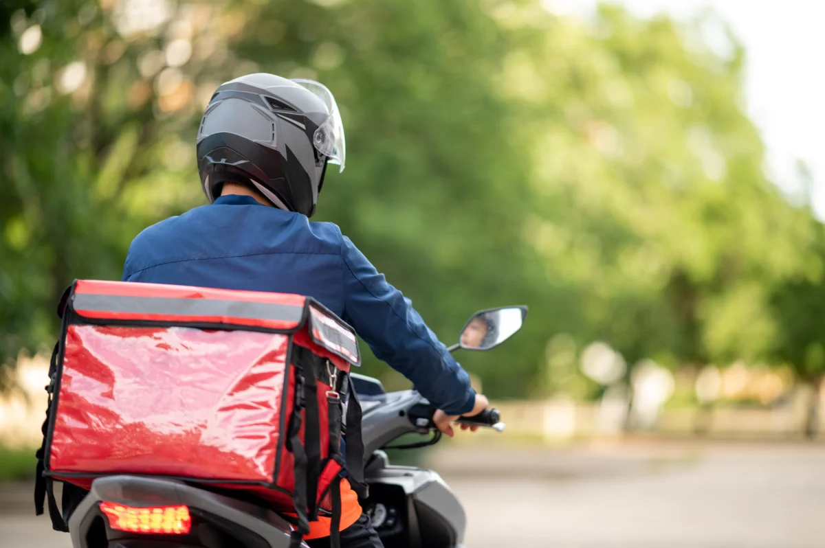 Entregador de aplicativo em motocicleta.