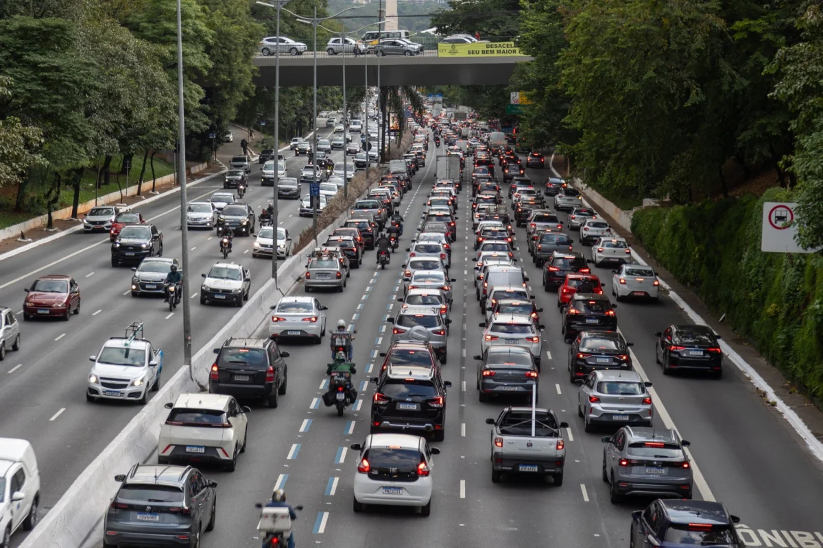 Tr&acirc;nsito de carros em uma avenida movimentada.