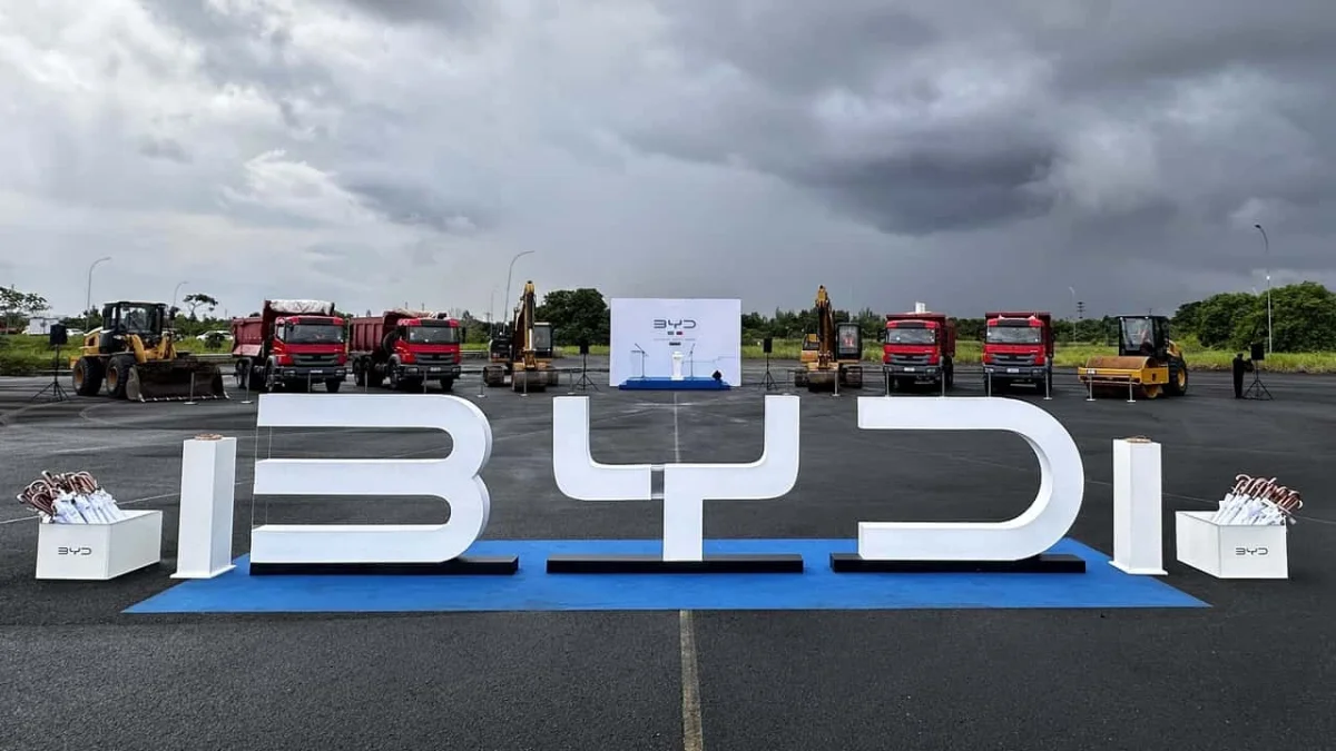 Planta de fábrica da BYD com maquinário e veículos.