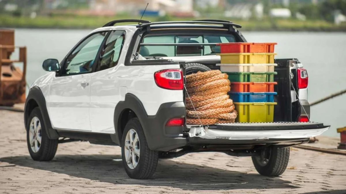 Fiat Strada branca com ca&ccedil;amba carregada.