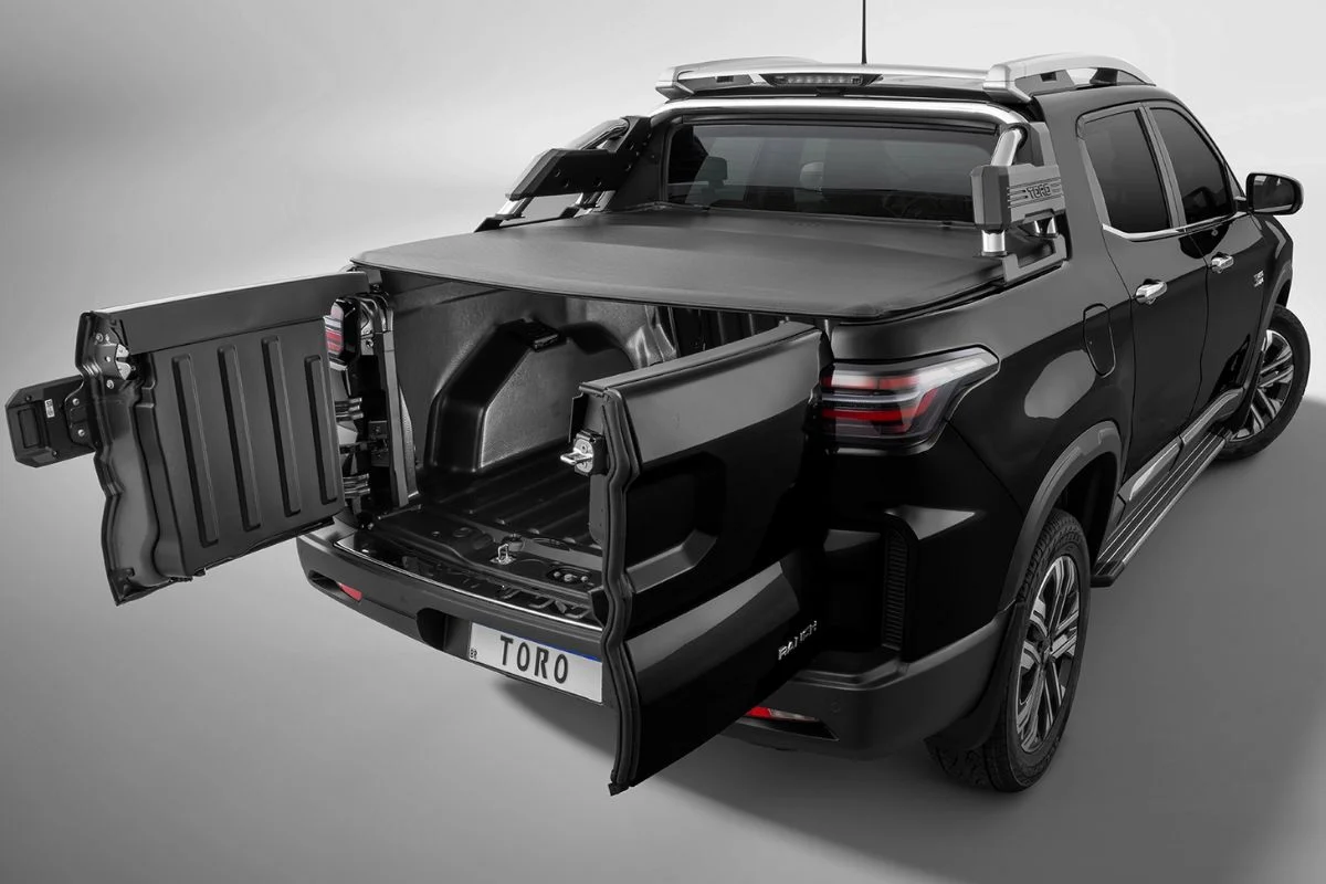 Imagem lateral de uma Fiat Toro de cor escura.