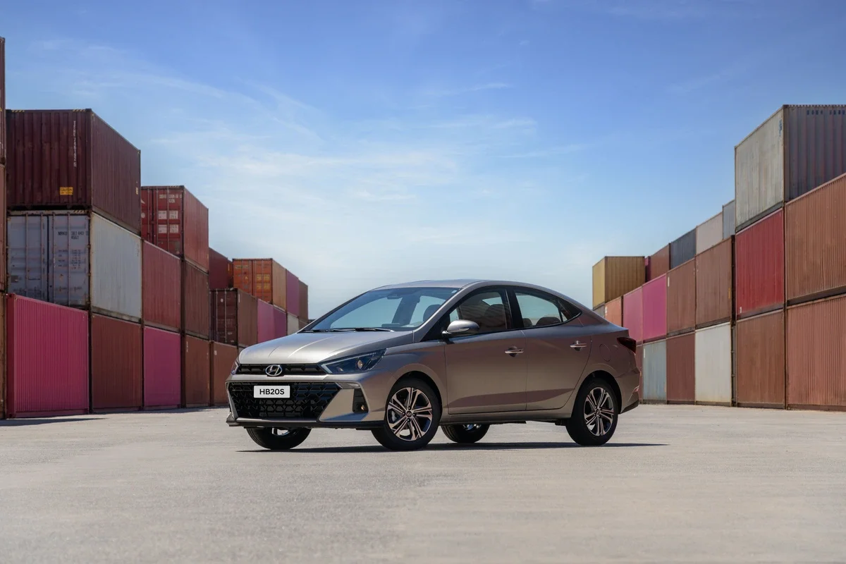 Hyundai HB20S estacionado em frente a contêineres coloridos.