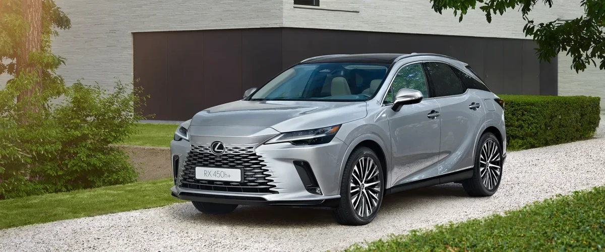 SUV Lexus RX em uma estrada ao lado de um prédio moderno