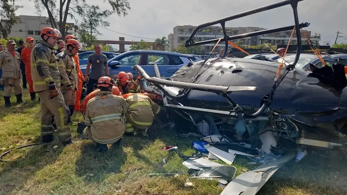 Bombeiros em volta de destro&ccedil;os de um helic&oacute;ptero ca&iacute;do
