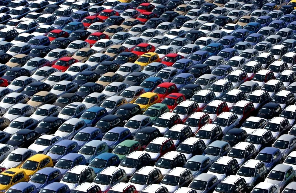 Vista a&eacute;rea de um grande p&aacute;tio de estacionamento com muitos carros.