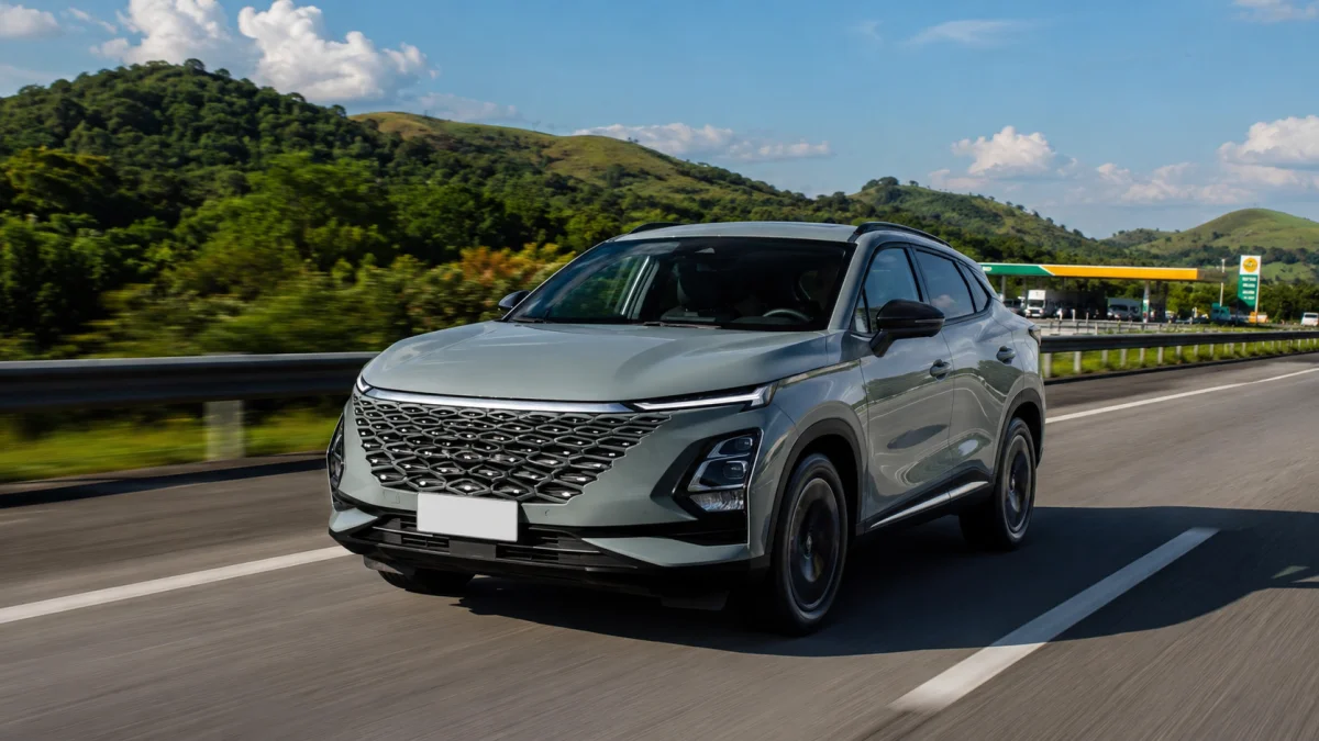 SUV moderno em uma estrada com montanhas ao fundo.