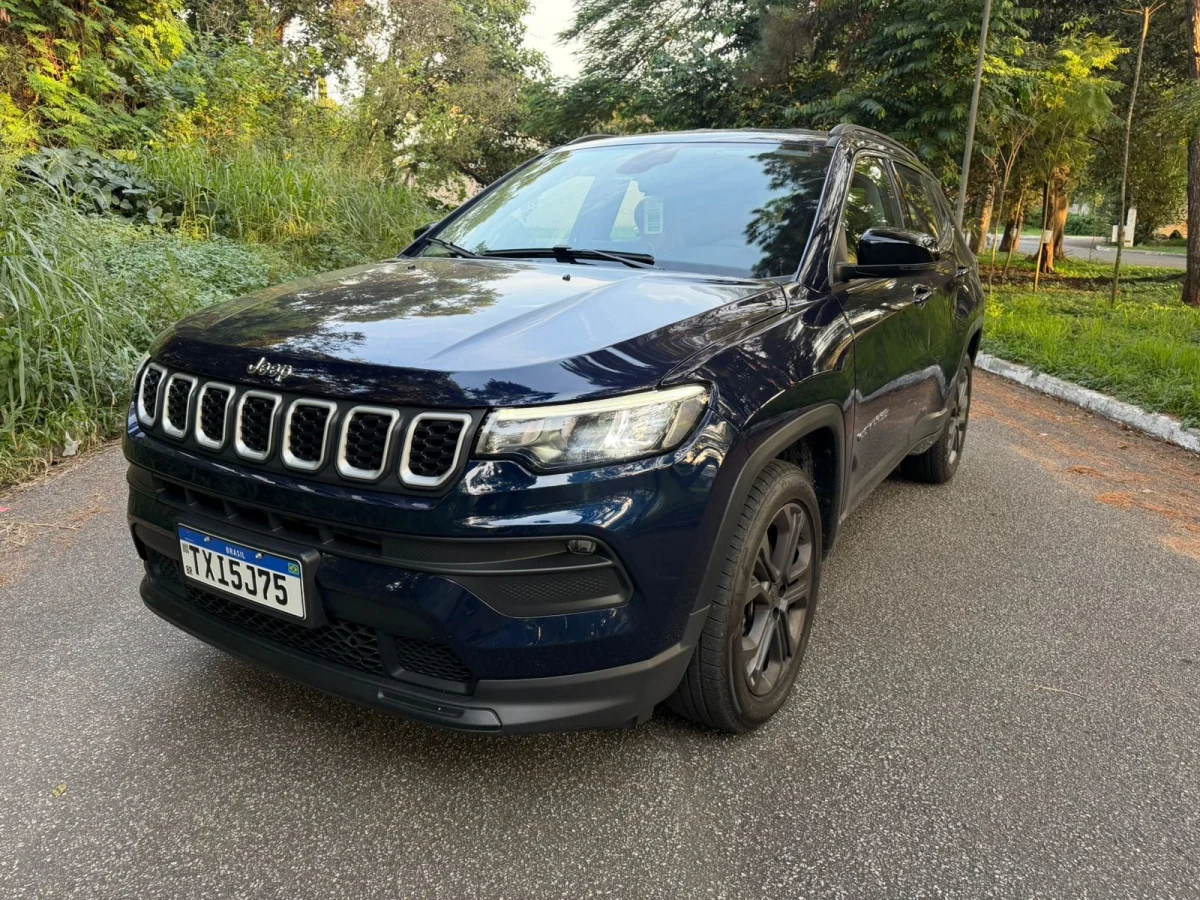 Vista frontal do Jeep Compass em uma estrada arborizada