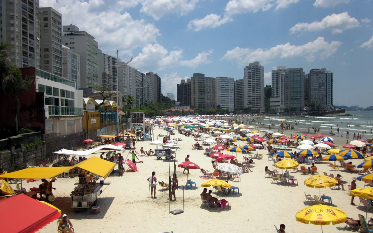 Praia de Pitangueiras no Guaruj&aacute; com diversos banhistas.